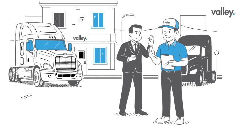 Mechanic inspecting an older semi truck in a repair bay